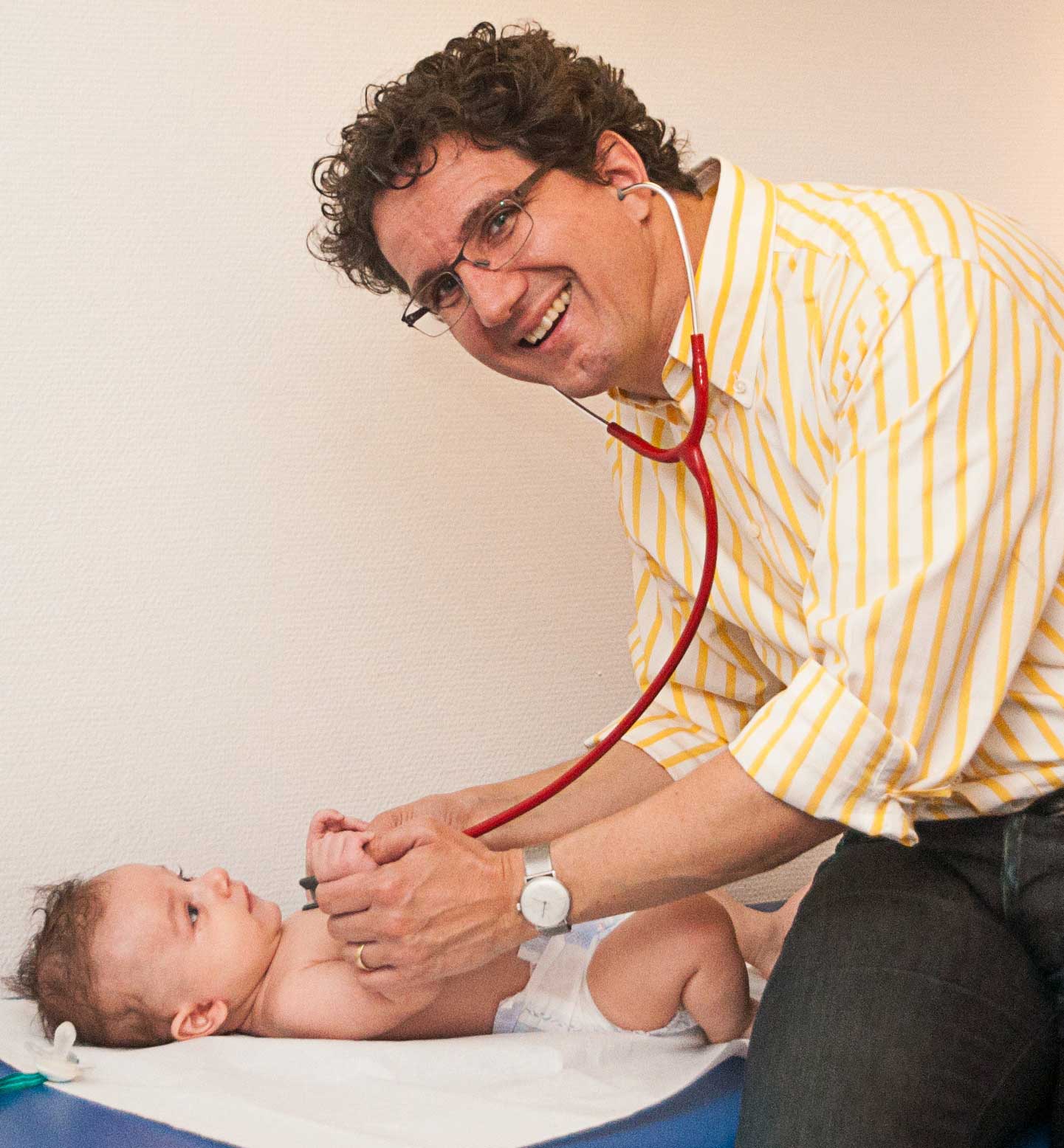 Dr. med. Marcel Ohlig untersucht einen Säugling, Kinderarzt in Mannheim